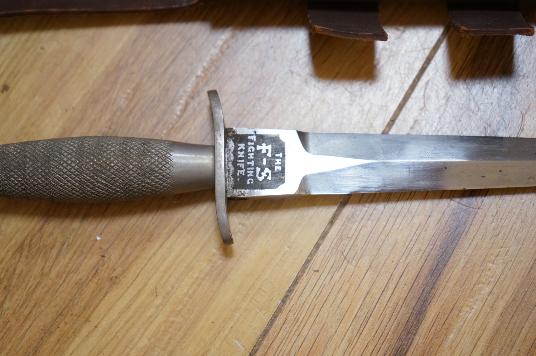 A Sykes-Fairburn Fighting Knife by Wilkinson sword in its leather scabbard, together with a 1942 Mk.III military compass by T.G.Co.Ltd. in a webbing pouch dated 1940, together with another compass, a telescope in a leath